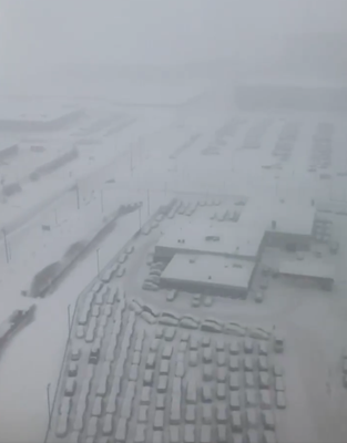 A snow covered city with cars and buildings